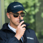 Portrait Of Young Security Guard Talking On Walkie-talkie